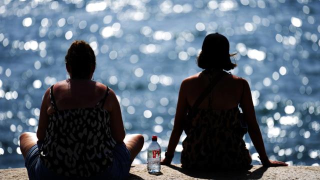 Dos personas observan el mar en la playa de la Barceloneta