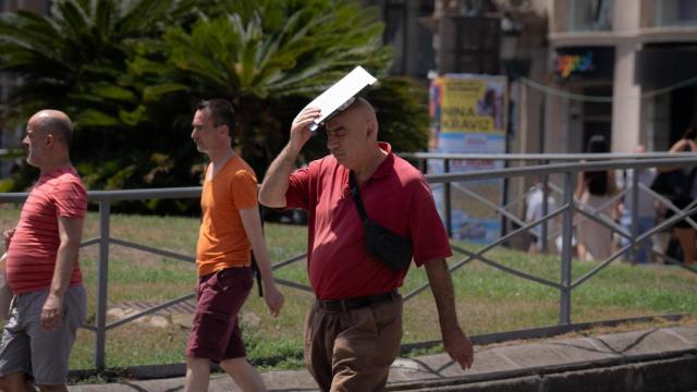 Una persona trata de protegerse del sol en Las Ramblas (Archivo)